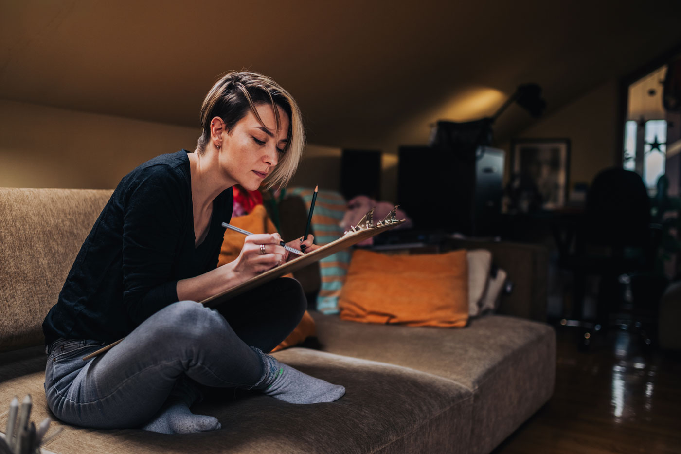 Mujer dibujando en el sofá